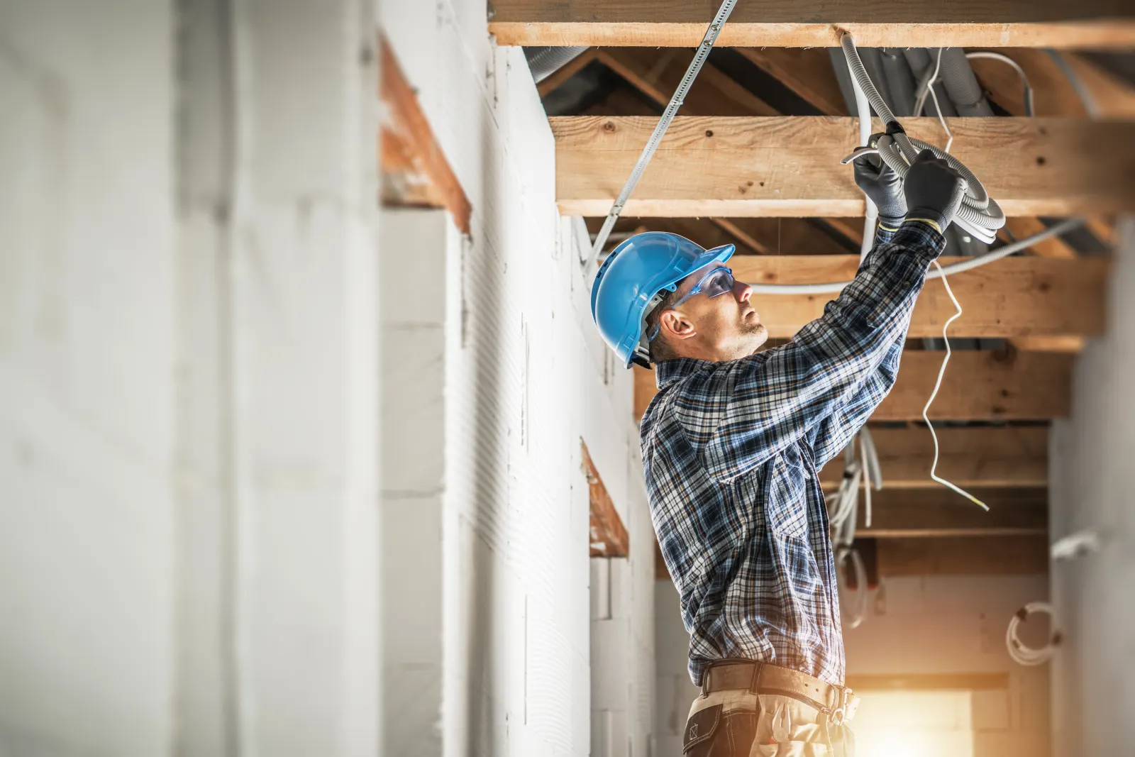 Electrician installing electrical wiring in new construction